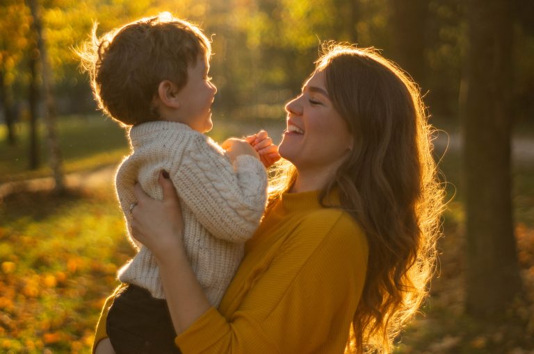 Mother and son walking in the Park and enjoying the beautiful autumn nature